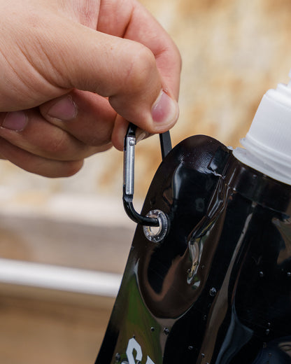 Eine Nahaufnahme des schwarzen Karabiners der schwarzen Kunststoffflasche. 