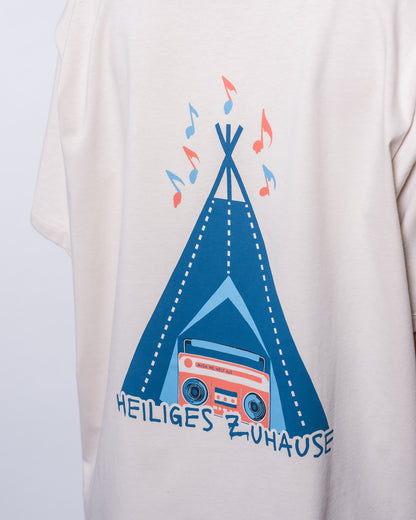 Das Bild zeigt den Aufdruck auf der Rückseite des T-Dresses. Es ist ein blaues Tippy im 2D-Look. Vor dem hellblau gezeichneten Eingang ist eine  coral Farbene Musikbox im Radiostil abgebildet. Über dem Tippy fliegen orangene und blaue Musiknoten.